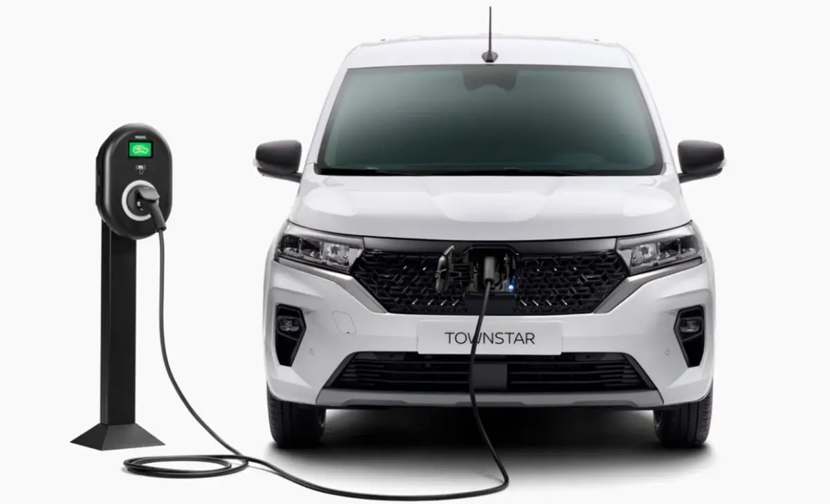 Ein weißer Nissan Townstar wird an einer Ladesäule geladen.