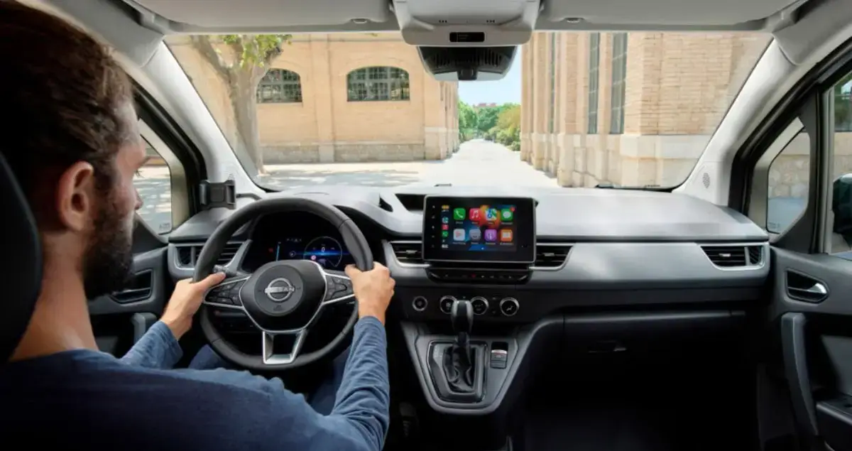Fahrer blickt aus dem Cockpit eines Nissan Townstar mit großem Touchscreen in der Mittelkonsole.