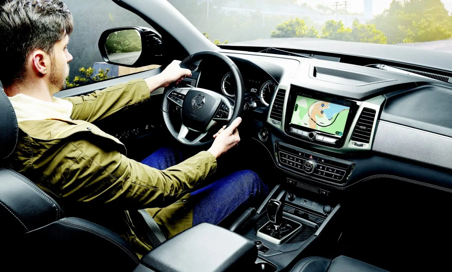 Cockpit des KGM Musso mit Fahrer und Navigationssystem im Einsatz.