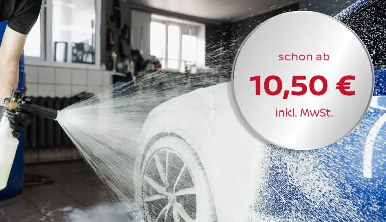 Ein Mitarbeiter beschäumt ein Auto mit einem Reinigungsschaum.