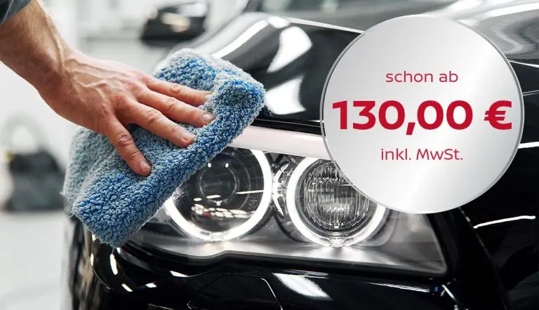 Eine Hand poliert mit einem Mikrofasertuch den Lack eines Autos.