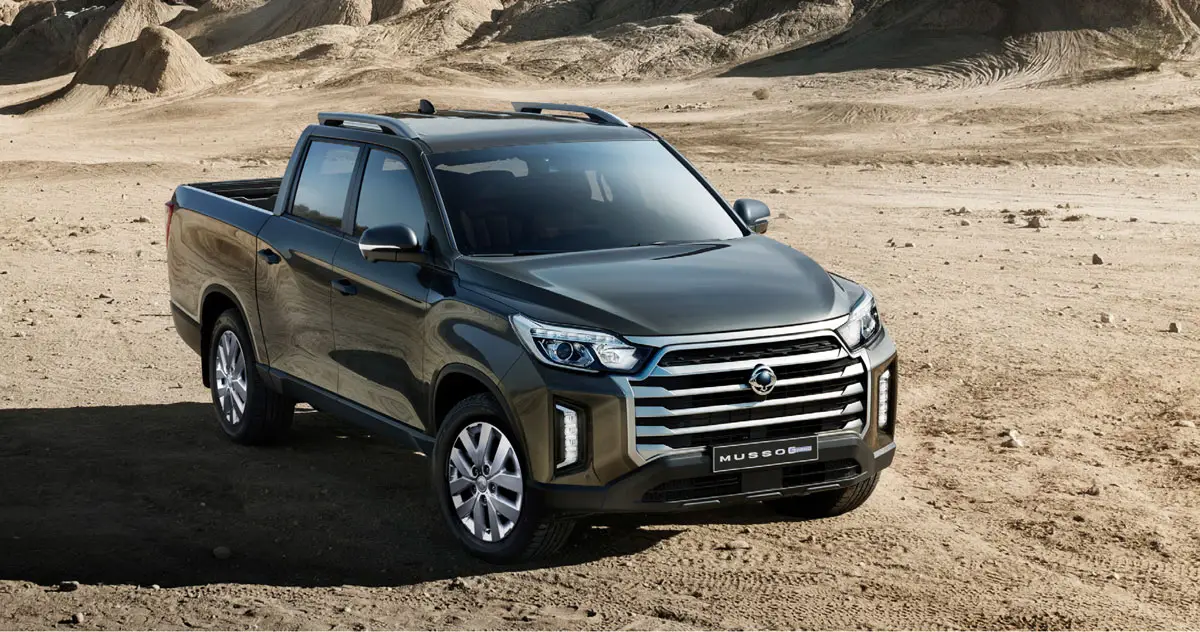 KGM Musso Grand in dunklem Metallic-Lack in einer Wüstenlandschaft